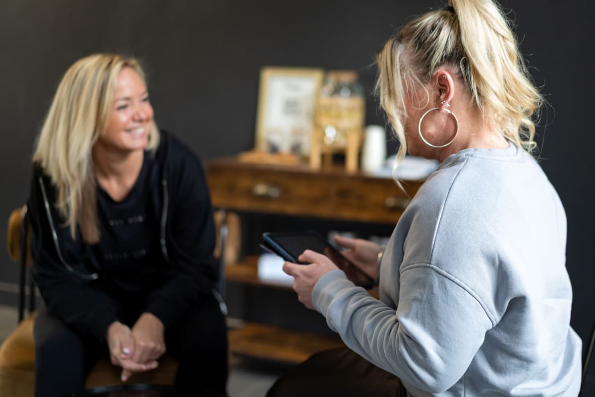 Un coach échange avec une cliente lors d’un bilan au studio